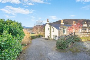A rural setting with a white building, a gravel path, and a stone bridge. - 5 Bed in Keswick (oc-h33619) (Keswick)