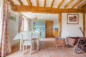 A rustic dining room with a wooden ceiling, a table set for two, and a vintage cart. - 2 Bed in Erpingham (oc-2278) (Erpingham)