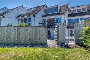 A two-story house with a balcony, a wooden fence, and a gated entrance. - 3 Bed in Saundersfoot (oc-pw9101) (Saundersfoot)