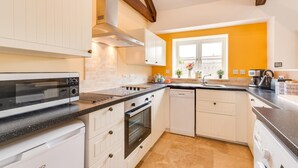 A modern kitchen with white cabinetry, a black countertop, a built-in oven, and a window with a view. - 2 Bed in Milfield (oc-nb1982) (Milfield)