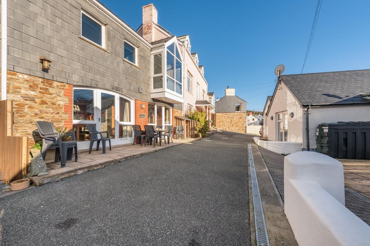 Eine Straße mit einer Reihe von Gebäuden, darunter ein Restaurant mit Terrassenplätzen.