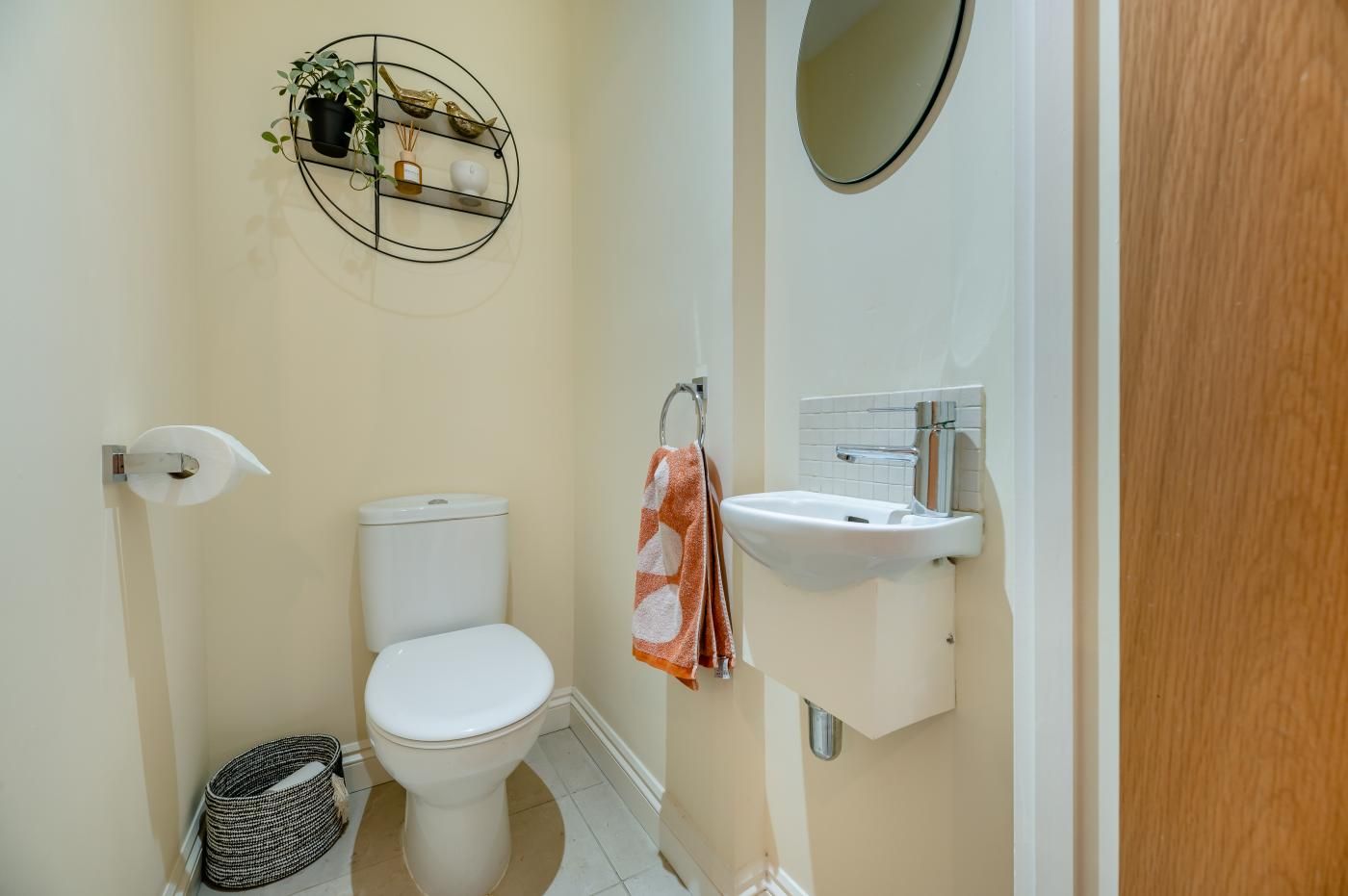 A bathroom with a toilet, sink, and a towel rack.