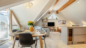 Um apartamento moderno estilo loft com área de refeições, cozinha e sala de estar.