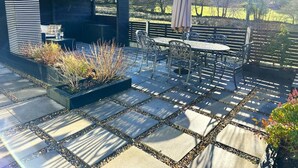 A patio area with a built-in grill, outdoor seating, and a garden bed. - 3 Bed in Brithdir (oc-c33971) (Brithdir)