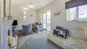 A living room with a sofa, armchair, and a fireplace. - 2 Bed in Snape (oc-12sf) (Snape)