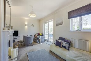 Ein Wohnzimmer mit Sofa, Sessel und Kamin.