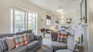 A living room with a grey sofa, armchairs, and a fireplace. - 2 Bed in Snape (oc-12sf) (Snape)