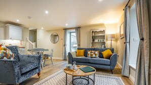 Un salon moderne avec un canapé gris, un fauteuil bleu et une table basse.