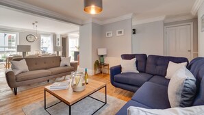 Un salon moderne avec un canapé marron, un canapé bleu et une table basse agrémentée d’objets décoratifs.