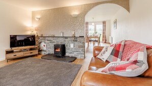 A cozy living room with a stone fireplace, a flat-screen TV, and a leather sofa. - 3 Bed in Bala (oc-bow26) (Parc)