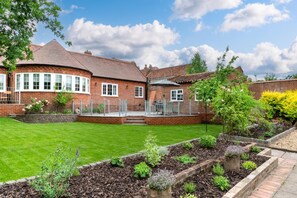 A brick house with a curved roof, a fenced patio, and a well-maintained garden. - 2 Bed in Beccles (oc-rilo) (Beccles)