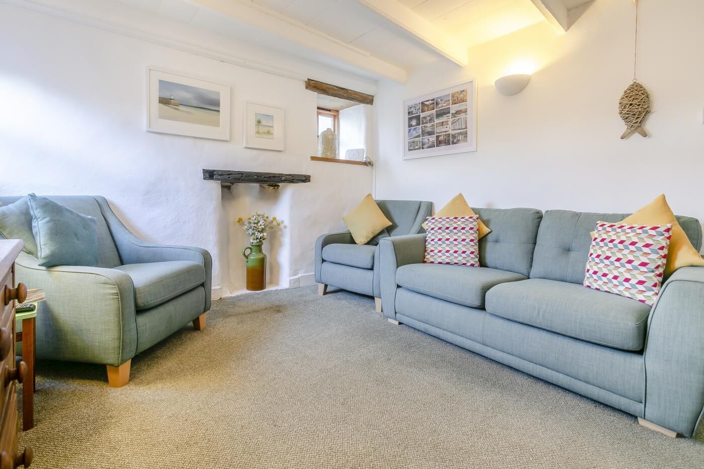 A cozy living room with two sofas, a small side table, and a decorative vase.