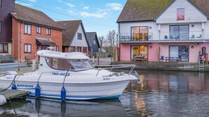 A boat named 'TWO JACKS' docked at a canal with houses on either side. - 4 Bed in Horning (oc-s34101) (Horning)