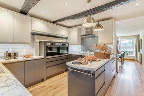 Mikrobølgeovn, ovn, oppvaskmaskin og høy barnestol