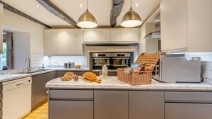 Una cocina moderna con encimera de mármol, electrodomésticos de acero inoxidable y una isla central con una cesta de mimbre.