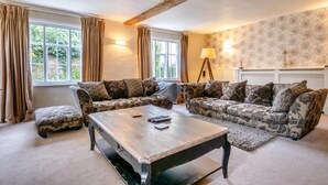 Ein Wohnzimmer mit zwei gemusterten Sofas, einem Holztisch und einer Lampe.
