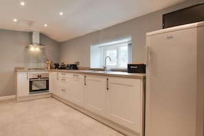 A modern kitchen with a built-in oven, a bread box, and a refrigerator. - 2 Bed in Tregaron (oc-bow289) (Blaenpennal)