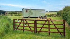 A green mobile home with a small porch and a table with chairs, surrounded by a wooden fence and a grassy field. - 1 Bed in Farnsfield (oc-s34109) (Farnsfield)