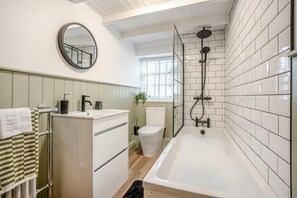 A bathroom with a bathtub, toilet, sink, and a mirror. - 3 Bed in Pickering (oc-t33630) (Pickering)