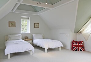 A bedroom with two beds, a window, a door, and a flag pillow. - 3 Bed in Ufford (oc-sfmea) (Ufford)