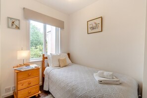 A bedroom with a bed, a wooden dresser, a window with a view, and two framed pictures on the walls. - 2 Bed in Orford (oc-sfcto) (Orford)
