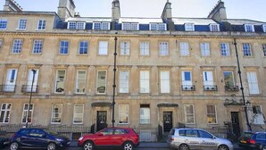 A row of townhouses with a uniform facade, featuring evenly spaced windows and a central entrance. - 1 Bed in Bath (oc-bhr5) (Bath)