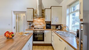 A modern kitchen with wooden countertops, a gas stove, an oven, and a sink. - 3 Bed in Alnwick (oc-80479) (Newton-by-the-Sea)