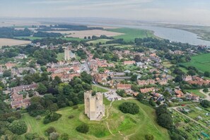 Ein Luftbild einer historischen Stadt mit einer markanten Burg, engen Gassen und einem Fluss.