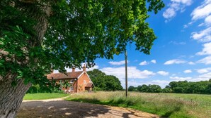 A rural house with a dirt path leading to it, surrounded by greenery and trees. - 2 Bed in Iken (oc-sfboo) (Iken)
