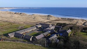 A coastal residential area with houses and a beach. - 2 Bed in Alnwick (oc-80494) (Newton-by-the-Sea)