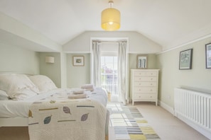 A bedroom with a bed, a dresser, a radiator, and a window with curtains. - 3 Bed in Woodbridge (oc-sfdor) (Woodbridge)