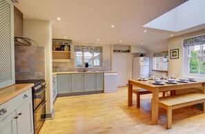 Een magnetron, een oven, een vaatwasser, kookgerei, borden en bestek