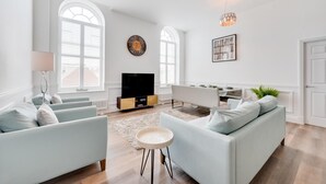 Un salon spacieux doté d’une grande télévision, de sièges confortables et d’un coin repas.