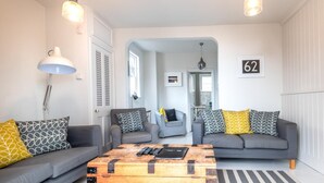 A modern living room with two grey sofas, a wooden coffee table, and a striped rug. - 4 Bed in Aldeburgh (oc-sfhan7) (Aldeburgh)