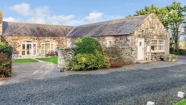 A stone building with a gravel driveway and a small garden area. - 4 Bed in Alnwick (oc-80496) (Newton-by-the-Sea)