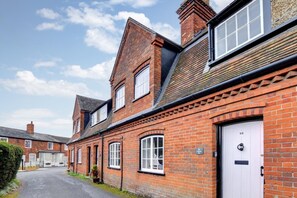 A row of red brick buildings with white doors, likely residential or small commercial properties. - 2 Bed in Orford (oc-sflpo) (Orford)