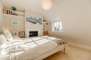 A bedroom with a bed, a fireplace, a bookshelf, and a window. - 2 Bed in Orford (oc-sflpo) (Orford)