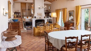 A cozy room with a dining table, chairs, a sofa, and a fireplace. - Peace and space in Vaison-la-Romaine for 16 people. (Saint-Romain-en-Viennois)