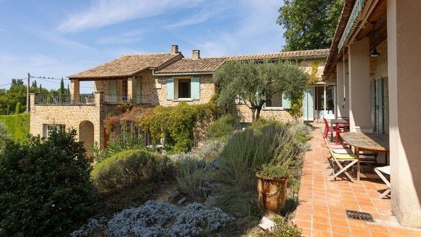 A stone house with a tiled patio, outdoor seating, and a garden with various plants. - Peace and space in Vaison-la-Romaine for 16 people. (Saint-Romain-en-Viennois)