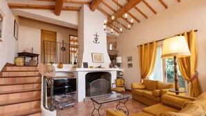 A living room with a fireplace, yellow sofas, and a staircase. - Peace and space in Vaison-la-Romaine for 16 people. (Saint-Romain-en-Viennois)