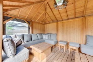 A wooden interior with a large sofa, a small table, and a bench. - 5 Bed in Southwold (oc-sfamo) (Southwold)