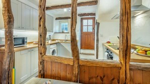 A kitchen with wooden beams, a microwave, a sink, and a window. - 2 Bed in Lindale (oc-c34128) (Lindale)