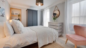 A bedroom with a bed, a dresser, a chair, a mirror, and a window. - 2 Bed in St. Ives (oc-upper4) (St Ives)