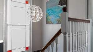 A staircase with white balusters and a wooden handrail, a white door with red accents, and a ceiling light fixture. - 2 Bed in St. Ives (oc-upper4) (St Ives)
