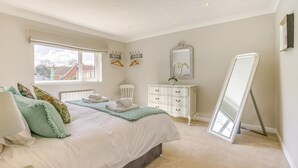 A bedroom with a bed, dresser, mirror, and window. - 2 Bed in Halesworth (oc-dak) (Halesworth)