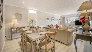 A modern living room with a dining area, a sofa, a TV, and a decorative vase. - 2 Bed in Halesworth (oc-dak) (Halesworth)