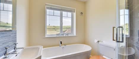 A bathroom with a bathtub, toilet, and two sinks.