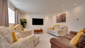 Una sala de estar con dos sofás, una mesa de centro y un televisor.