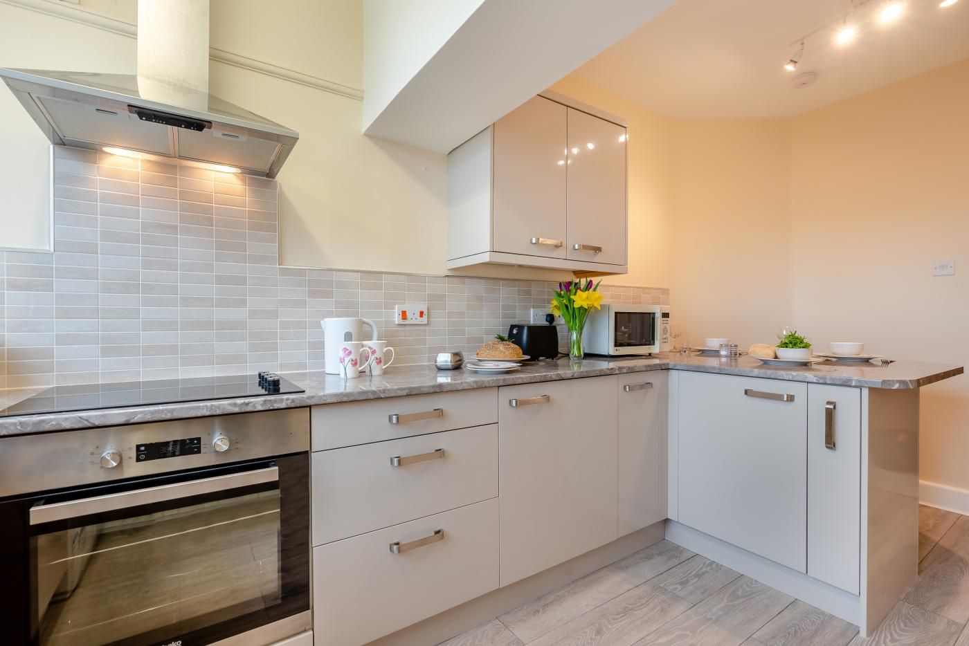 A modern kitchen with a built-in oven, microwave, and stainless steel cabinets.