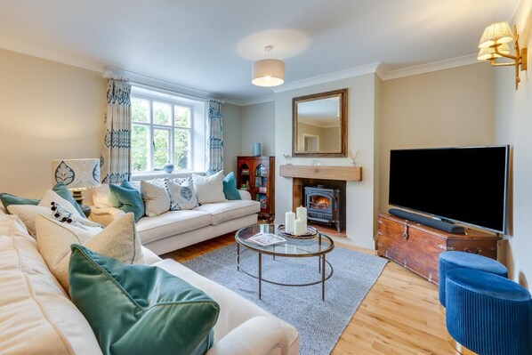 A living room with a sofa, a coffee table, a fireplace, and a television. - 4 Bed in Northrepps (oc-2332) (Northrepps)